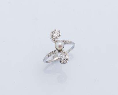 null Platinum (950 ‰) duchess ring set with a pearl, shouldered by two cushion-cut...