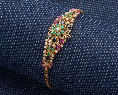 null 18K yellow gold bracelet (750 ‰) adorned with a flower set with emeralds, diamonds,...