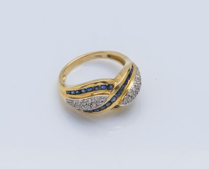 null An 18K (750 ‰) yellow gold band ring drawing a twist set with round diamonds...