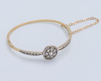 null 
A 14-carat yellow gold (585 ‰) and silver (800 ‰) open-worked bangle bracelet...