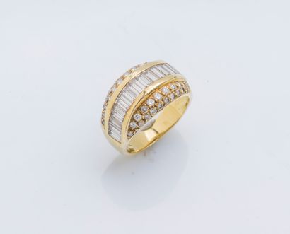 null An 18K (750 ‰) yellow gold cambered band ring set with a line of baguette diamonds,...