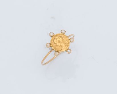 null An 18K (750 ‰) yellow gold ring adorned with a medal featuring a young girl...