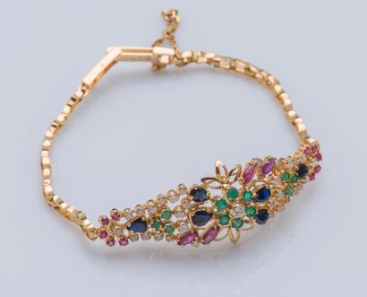 null 18K yellow gold bracelet (750 ‰) adorned with a flower set with emeralds, diamonds,...