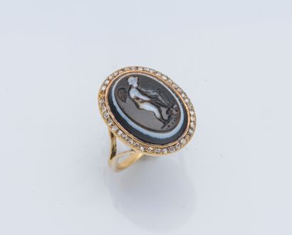 null An 18K (750 ‰) yellow gold ring adorned with a cameo on onyx depicting a cupid...