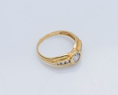 null An 18K (750 ‰) yellow gold godronnée band ring set with a 0.30-carat diamond...