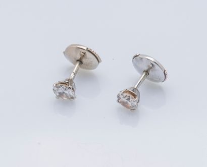 null A pair of 18K (750 ‰) white gold earrings each set with a calibrating diamond...