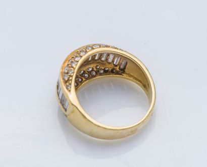 null An 18K (750 ‰) yellow gold cambered band ring set with a line of baguette diamonds,...