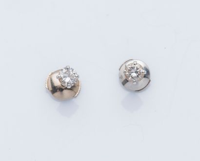 null A pair of 18K (750 ‰) white gold earrings each set with a calibrating diamond...