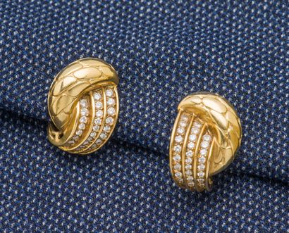 null A pair of 18K (750 ‰) yellow gold ear clips chased with scales and set with...