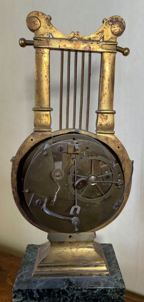 null A gilt bronze lyre-shaped clock, apparent mechanism (incomplete), resting on...