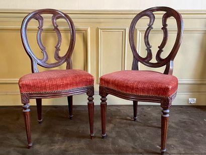 null A pair of carved moulded natural wood chairs, the medallion back resting on...
