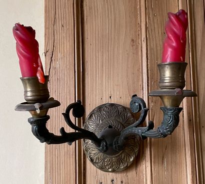 null A pair of patinated and gilt bronze sconces with two lights