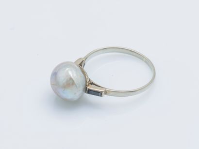 null 18K (750 ‰) white gold ring set with a button pearl (damaged) shouldered by...