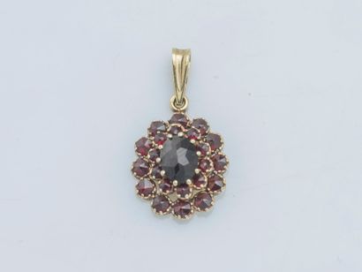 null 14K yellow gold pendant (585 ‰) adorned with an oval faceted garnet in a double...