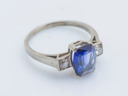  A 14-karat (585 ‰) white gold ring set with a Verneuil sapphire shouldered by two...