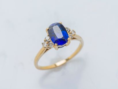 null An 18K (750 ‰) yellow gold ring set with an oval synthetic sapphire shouldered...