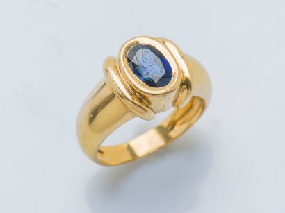  An 18K (750 ‰) yellow gold cambered band ring set with an oval sapphire of approximately...