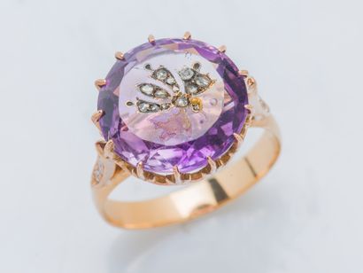 null An 18K (750 ‰) rose gold ring set with a round amethyst set with rose-cut diamonds...