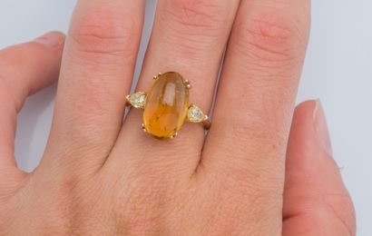null An 18K (750 ‰) rose gold ring set with an oval cognac tourmaline cabochon weighing...
