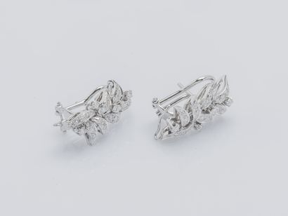  A pair of 18K (750 ‰) white gold earrings designing a leafy branch set with brilliant-cut...