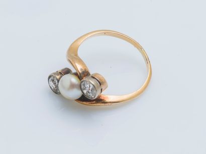 null An 18k yellow gold ring (750 ‰) set with a button half-pearl shouldered by two...