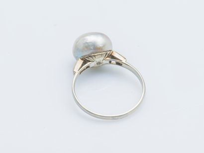  18K (750 ‰) white gold ring set with a button pearl (damaged) shouldered by two...