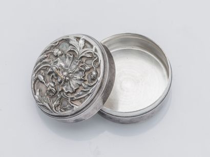  Boite à pilules de forme ronde en argent (800 ‰) à décor ciselé de fleurs de pavot....