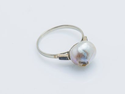  18K (750 ‰) white gold ring set with a button pearl (damaged) shouldered by two...