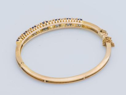  Bracelet jonc rigide ouvrant en or jaune 18 carats (750 ‰) la partie centrale sertie...