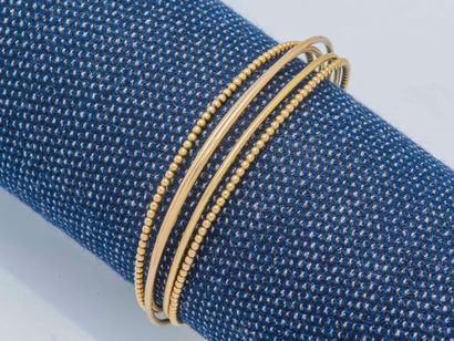  Rigid and opening 18K yellow gold (750 ‰) multi-jewel bracelet formed of three thin...