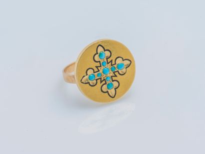 An 18K (750 ‰) yellow gold ring the round bezel adorned with a lily cross highlighted...