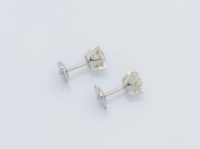 null 
A pair of 18k (750 ‰) white gold earrings adorned with an old-cut diamond weighing...