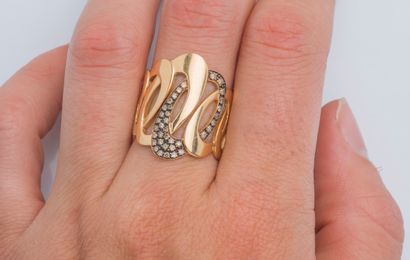  An 18K (750 ‰) rose gold band ring drawing interlaced rings, one of which is set...