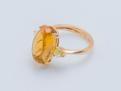  An 18K (750 ‰) rose gold ring set with an oval cognac tourmaline cabochon weighing...