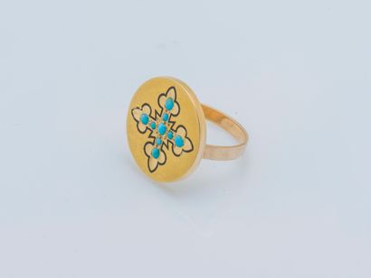null An 18K (750 ‰) yellow gold ring the round bezel adorned with a lily cross highlighted...