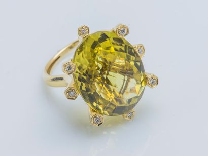 null An 18K (750 ‰) yellow gold ring set with a large faceted oval lemon quartz weighing...