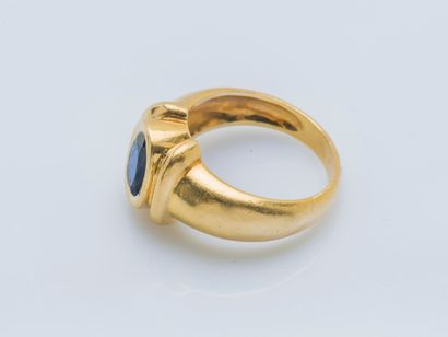  An 18K (750 ‰) yellow gold cambered band ring set with an oval sapphire of approximately...