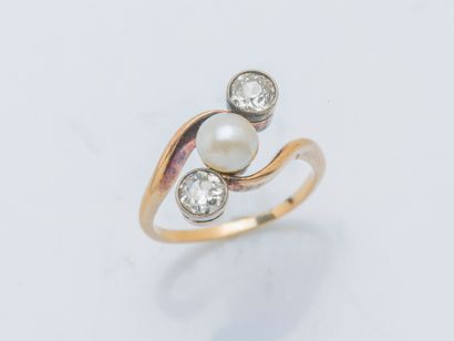 null An 18k yellow gold ring (750 ‰) set with a button half-pearl shouldered by two...