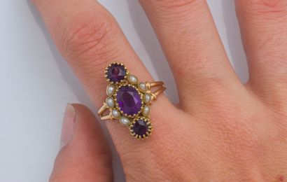  An 18K (750 ‰) yellow gold marquise ring set with an oval amethyst circled with...
