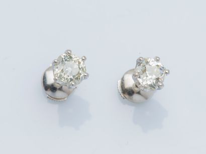 null 
A pair of 18k (750 ‰) white gold earrings adorned with an old-cut diamond weighing...