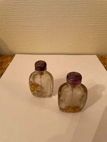 null Two rock crystal snuff bottles with floral decoration in relief in an ochre...