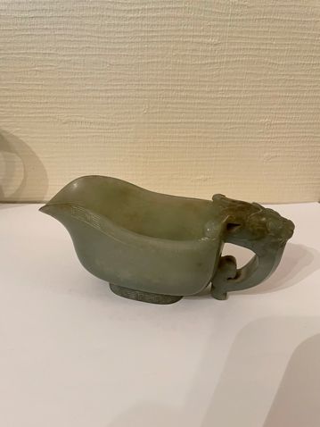 null Celadon jade yi type jug, with handle spat out by a ram's head, the rim and...