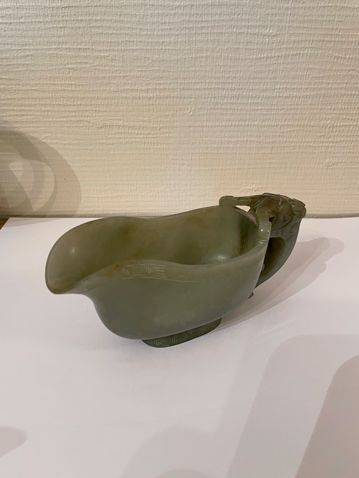 null Celadon jade yi type jug, with handle spat out by a ram's head, the rim and...