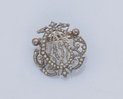  Broche fleuron en argent (800 ‰) dessinant un monogramme sertie de semences de perle,...