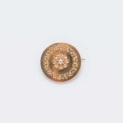 null Broche ronde en or jaune 18 carats (750 ‰) à décor ciselé, ornée d’une fleur...