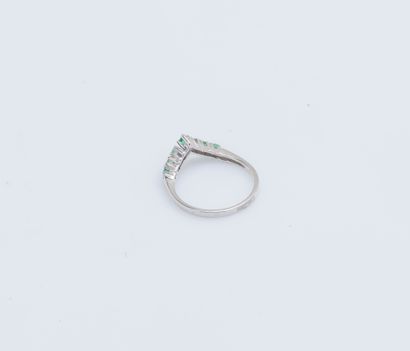 null 18K (750 ‰) white gold ring set with a line of small round emeralds (chips)...