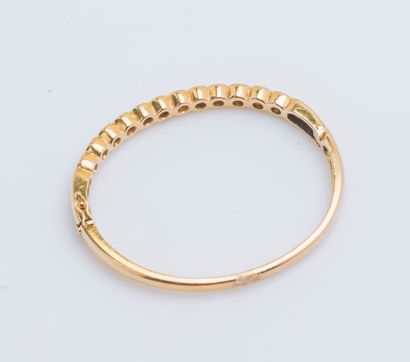 null 18K yellow gold (750 ‰) opening bangle bracelet adorned with a line formed of...
