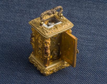  Pendulette de voyage en bronze doré (manques) de forme cabinet à décor de figures...
