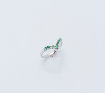 null 18K (750 ‰) white gold ring set with a line of small round emeralds (chips)...