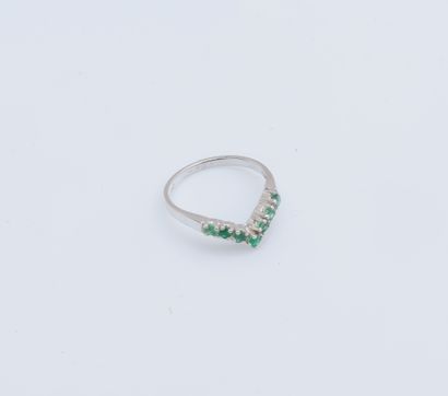 null 18K (750 ‰) white gold ring set with a line of small round emeralds (chips)...